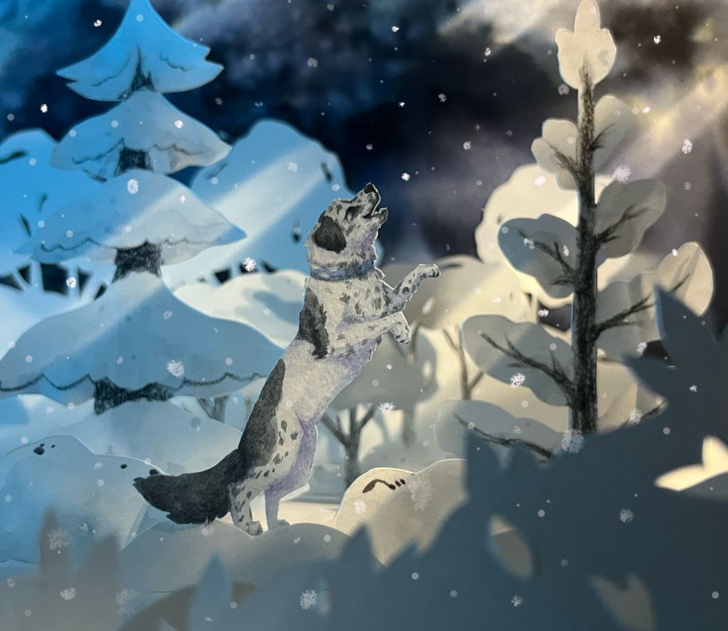 Paper craft diorama of a dog catching snow in the winter forest