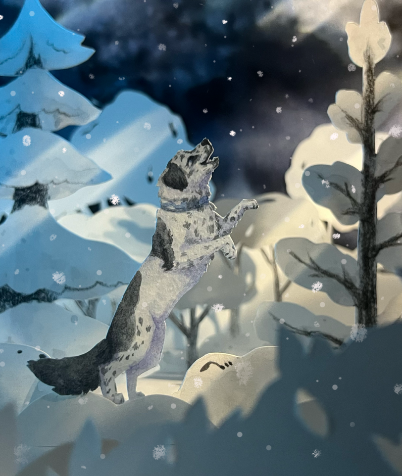 Paper craft diorama of a dog catching snow in the winter forest