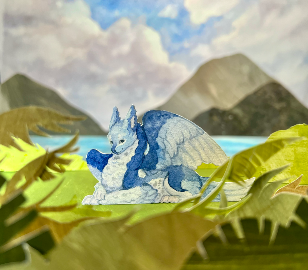 Paper craft diorama of a blue dragon on an island