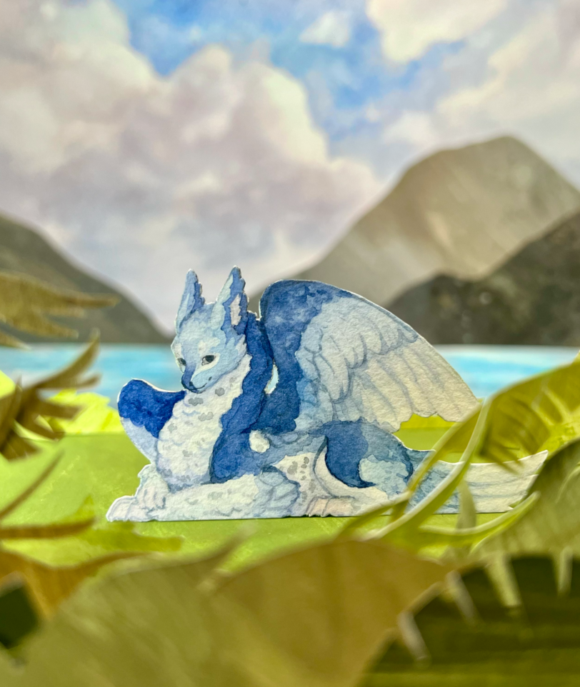 Paper craft diorama of a blue dragon on an island