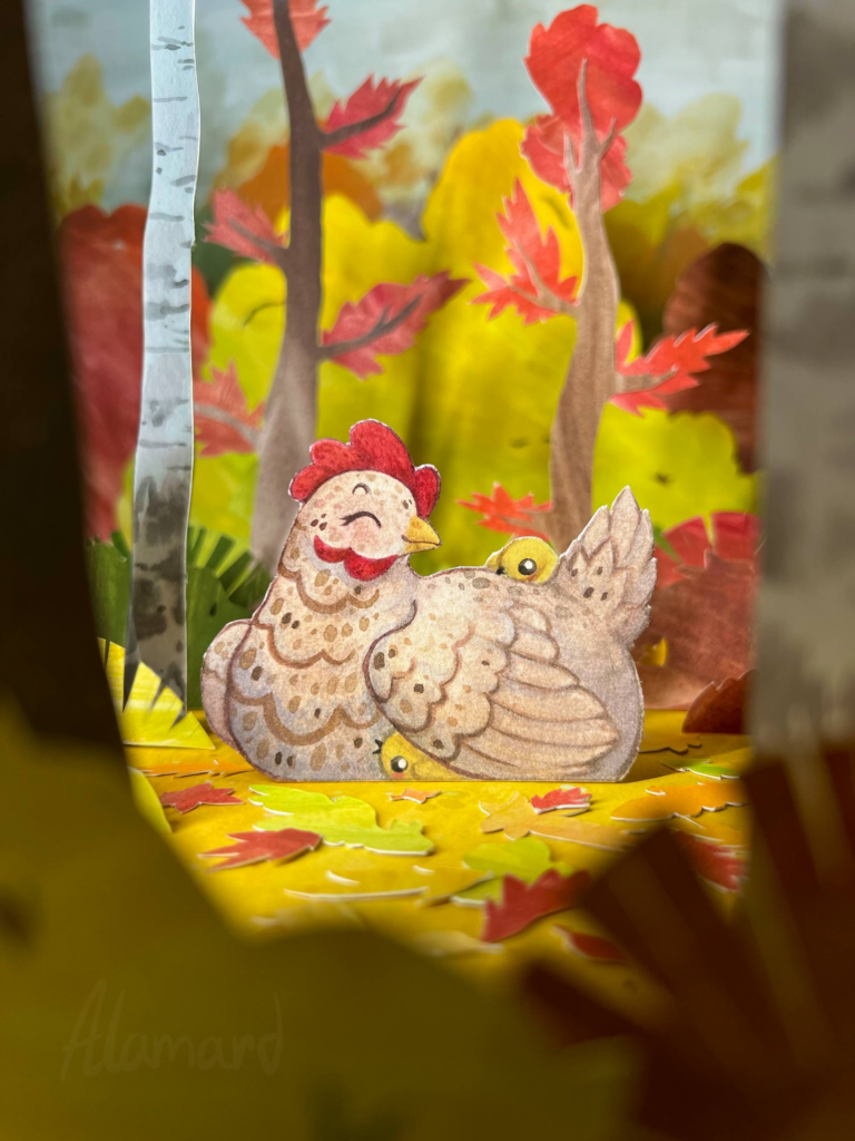 Paper craft diorama of a chicken with her chicks in an autumn forest