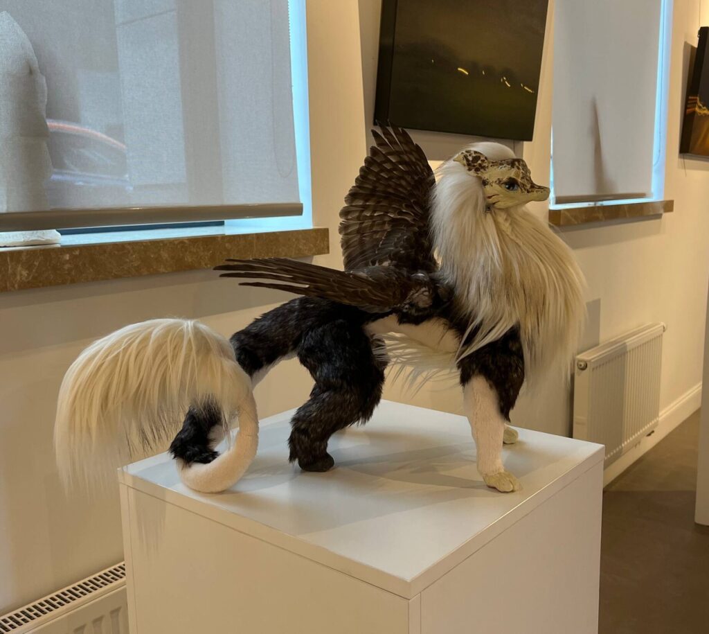 Handmade poseable fantasy dragon art doll in a gallery